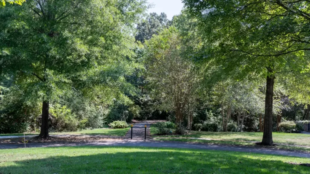 Paved Cottage Creek neighborhood connector entrance with two bollards in Farragut, Tennessee