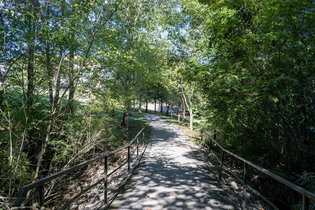 Wooded paved connector with railings leading from the Inverness Greenway toward Hidden Grove Road in Farragut TN